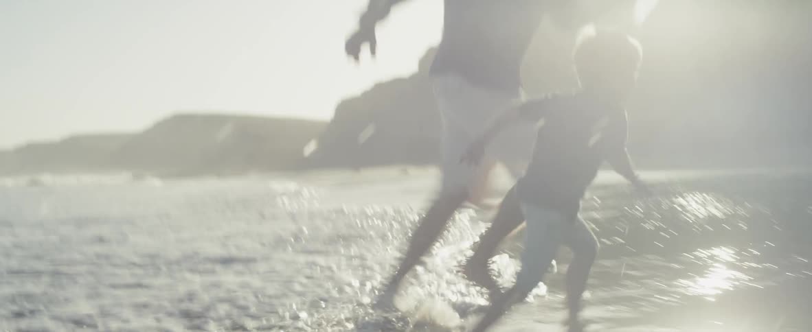 A dad and his son play in the surf on a beach