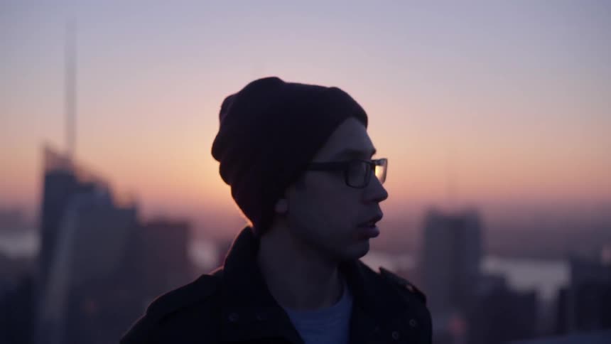 Man standing and looking around at sunset