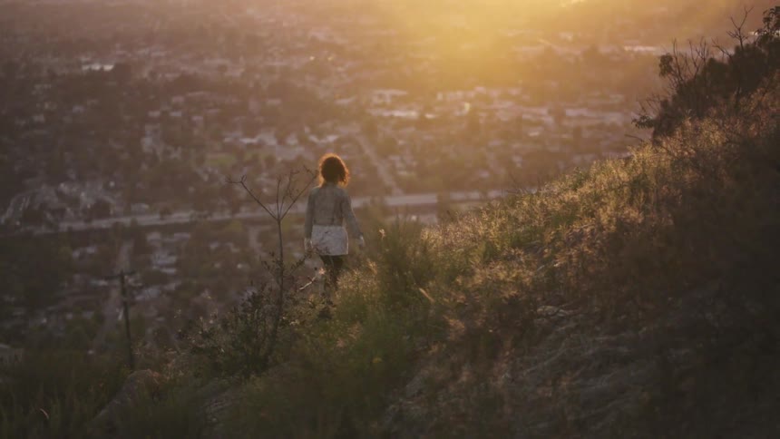 A woman walks up a large hill