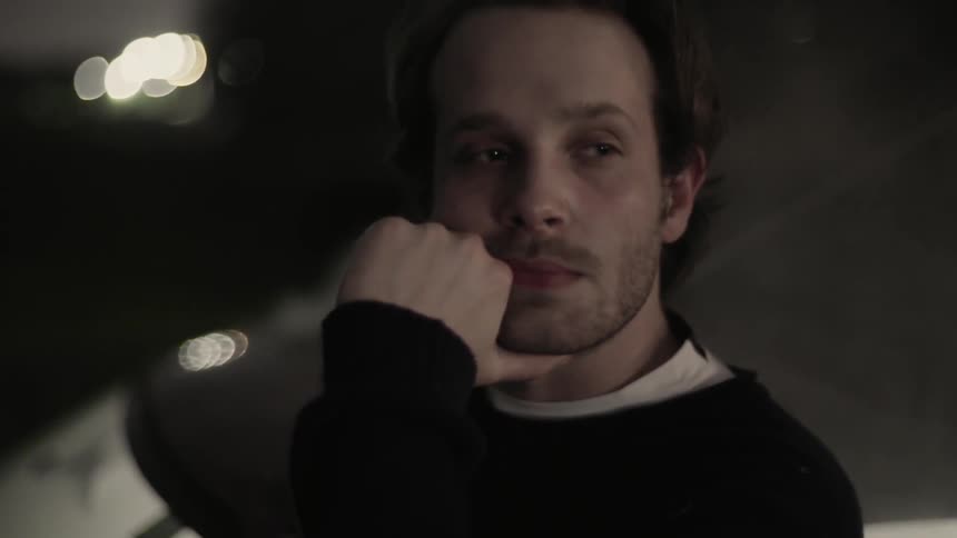 Man puts his hand on his chin and looks to his side