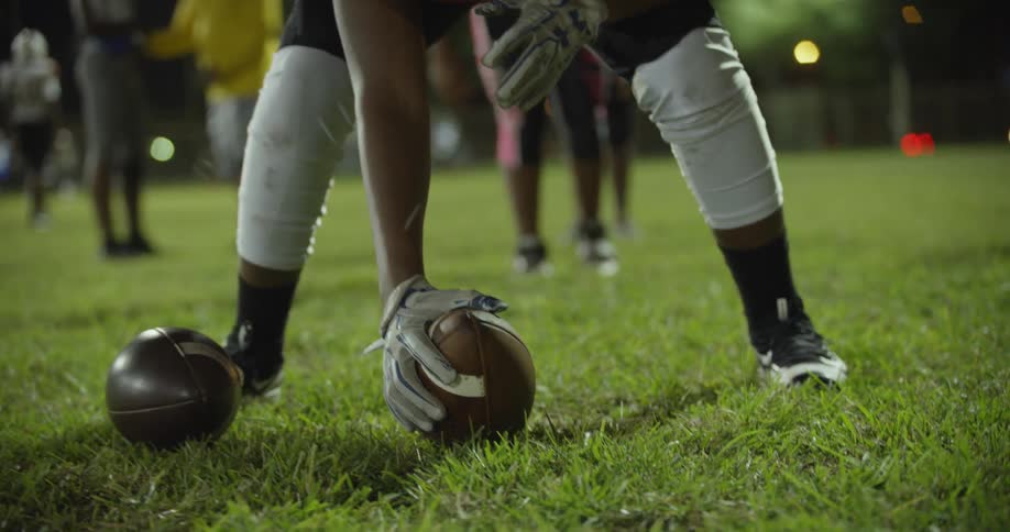Boys play football at night