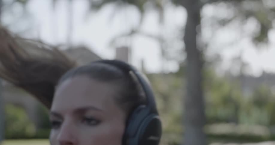 Woman jogging in neighborhood wearing headphones