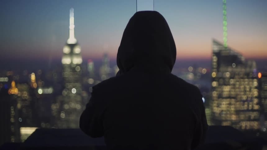 A man stares out at the city during the evening