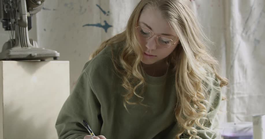 Artist Student writes in a notebook