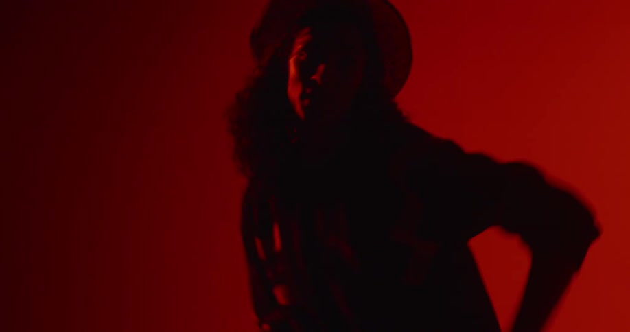 A man dances in a room with flashing lights