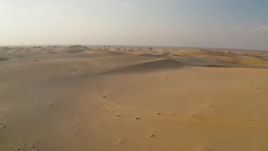 Sand dunes cover a desert landscape