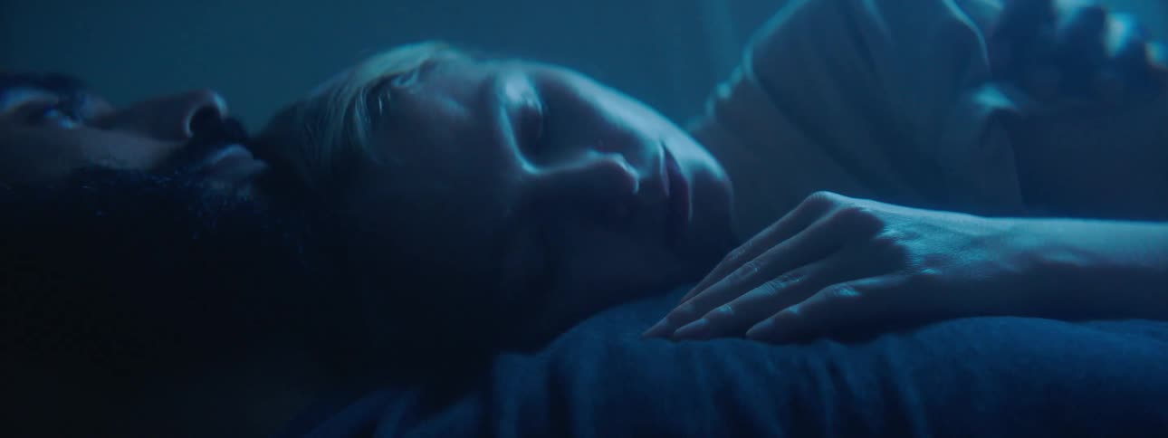 A man and woman cuddle while sleeping