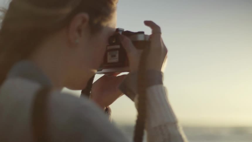 Woman takes a picture of the ocean