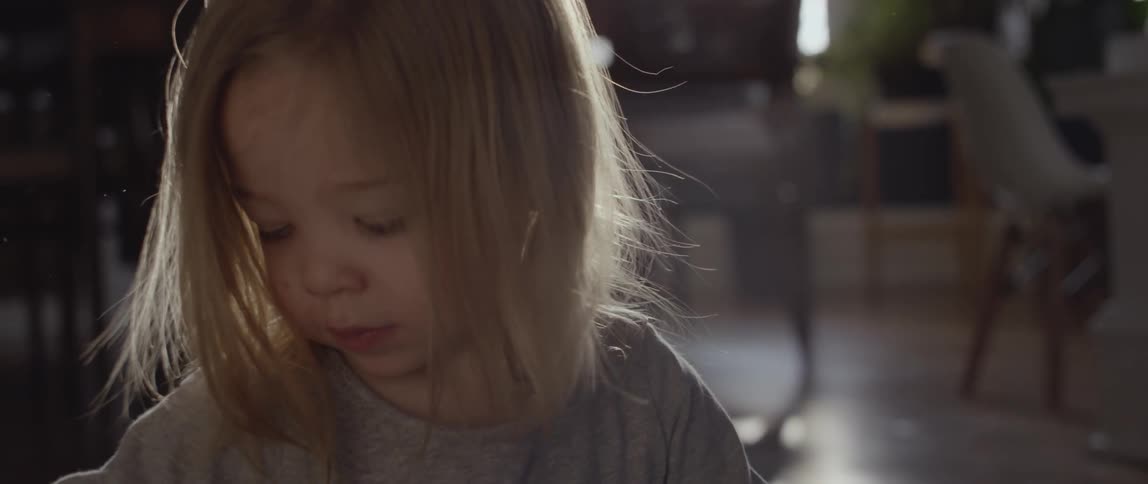 Child sits in a house with sun shining in