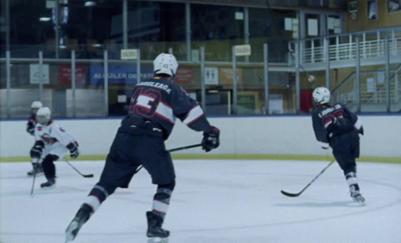 Hockey players skate on an ice rink