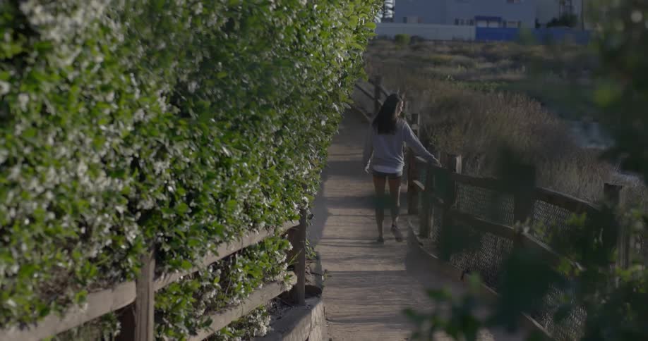 Woman walks on a wooden walkway