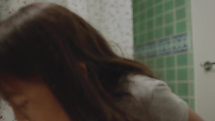 Child brushes her teeth in a bathroom