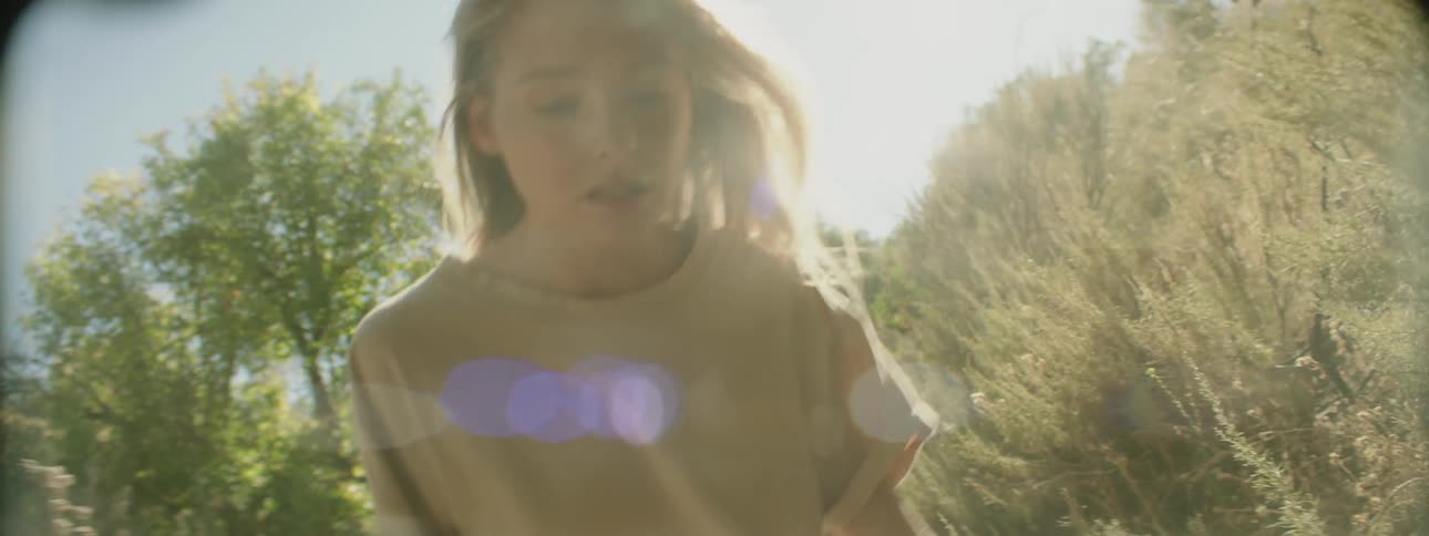 Woman and man trudge through the woods on a sunny day