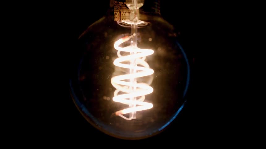 Light bulb shines bright in a dark room