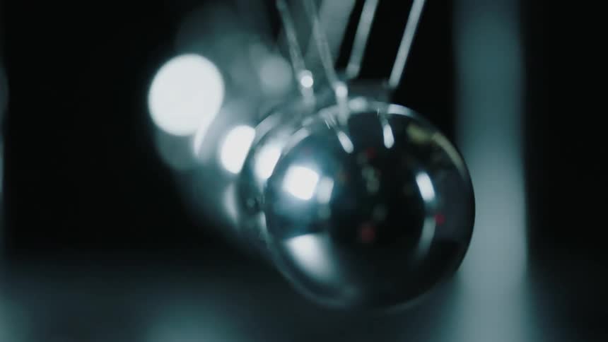 Metal balls hit each other and swing back and forth