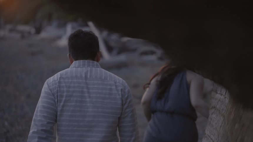 A man and woman walk on the beach