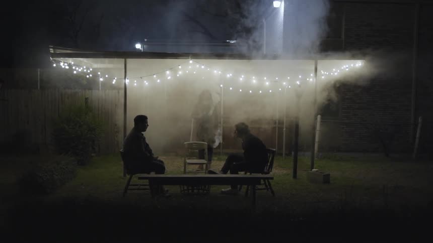 Smoke billowing around three people outside