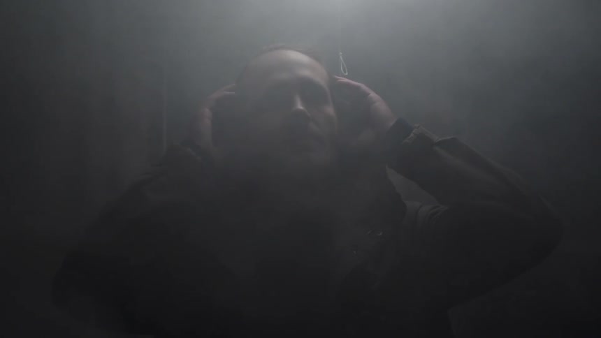 Man removes hood in a smoky room