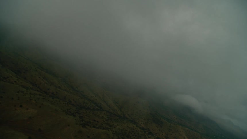 Hazy clouds hang above the hilly landscape
