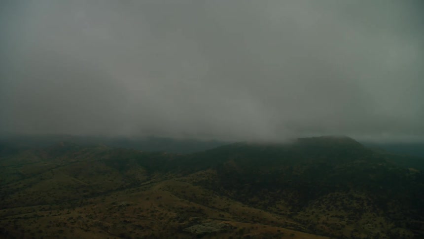 Clouds float above a rural mountain landscape