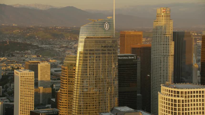 Sunlight is reflecting in the windows of skyscrapers in a city during the morning