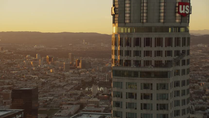 Tall building with many windows stands tall in a city
