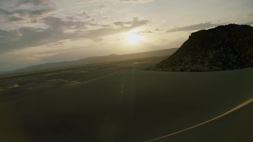 Sun shines over sandy hilly desert