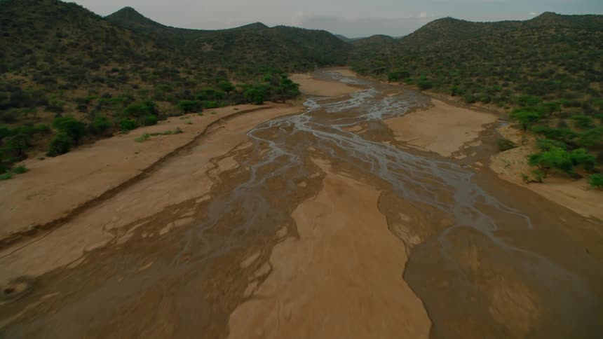 A muddy stream winds through a landscape