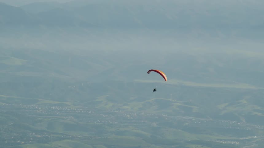 A man parachutes down from the sky