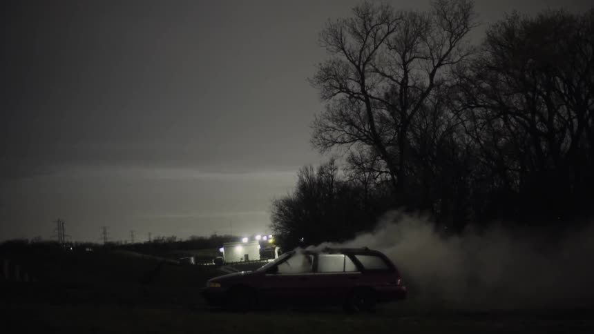 Smoke billowing from a parked car