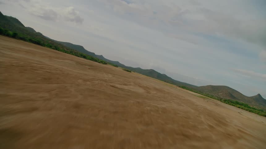 A dirt field covers a rural landscape