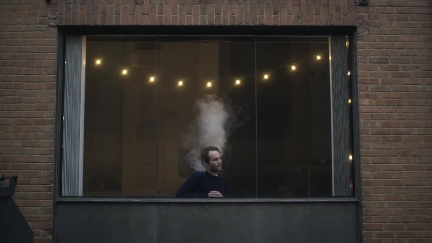 A man smoking on a balcony