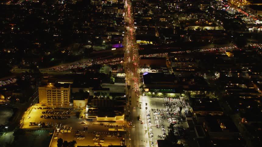The brightly lit city below is busy with moving vehicles