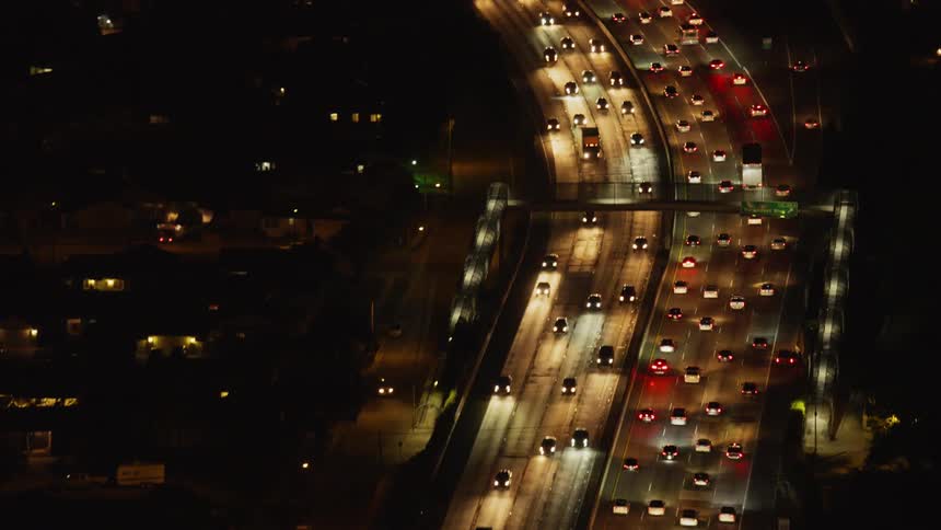 The vehicles travel slowly down the freeway at night