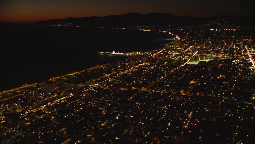 The coastal city is brightly lit at night