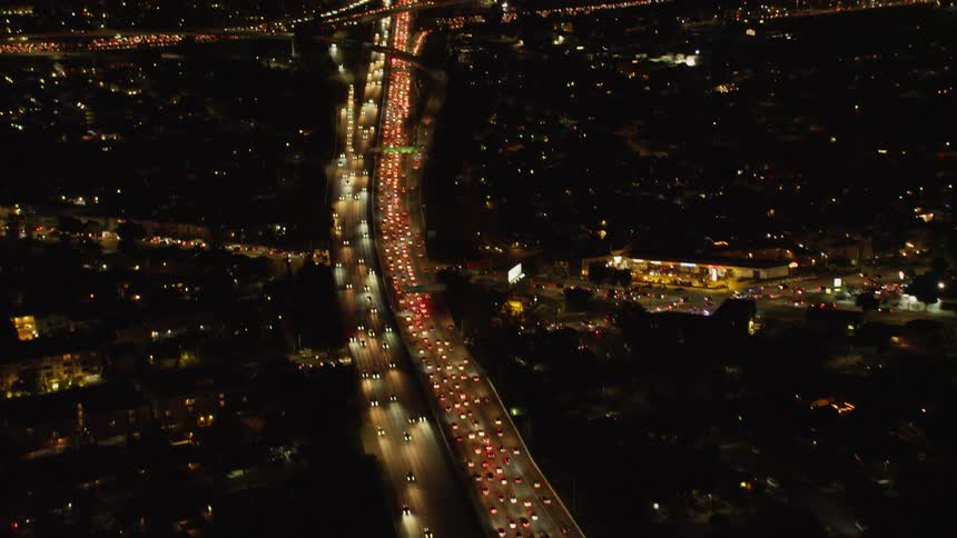 The lanes are full of vehicles lighting up the road at night