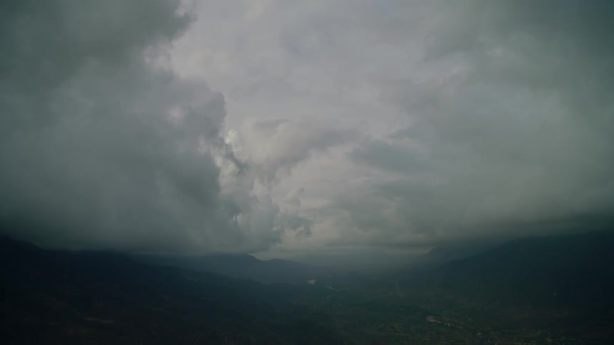 Storm clouds rotate above the mountains