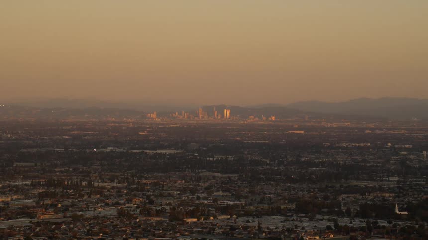 A landscape of buildings and neighborhoods is sprawling out from a city at dawn