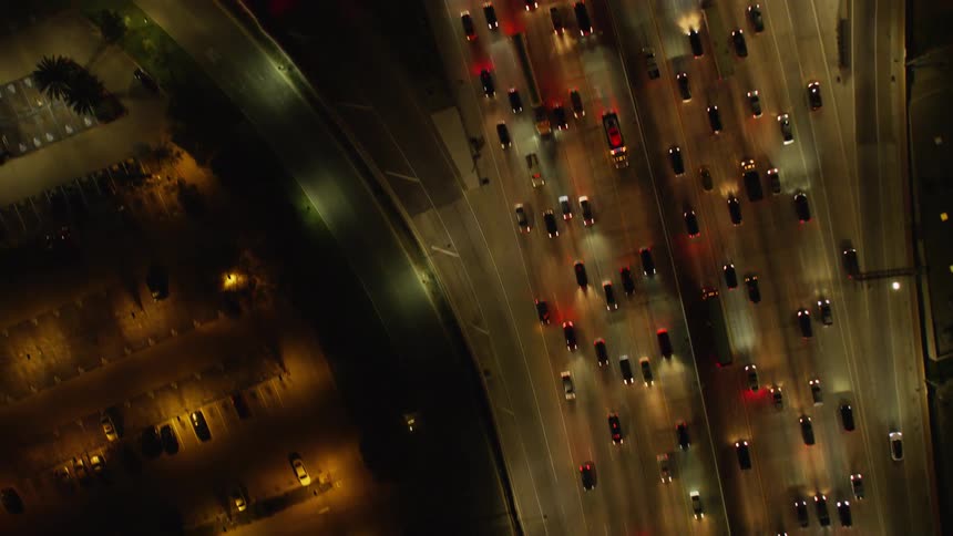 Cars drive on a city street at night