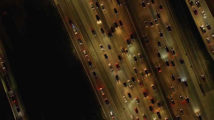 Cars drive on a city highway at night