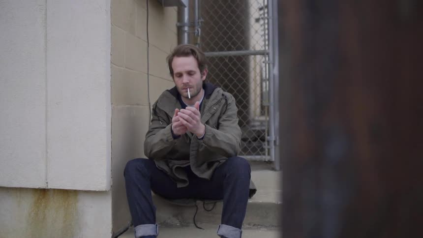 A man is smoking outside
