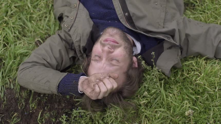 A man is lying in a field