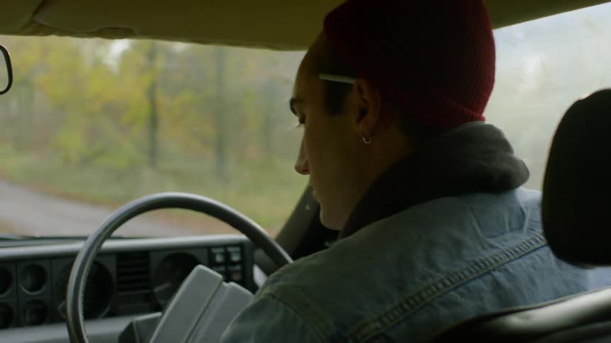 A man drives and parks in a forest