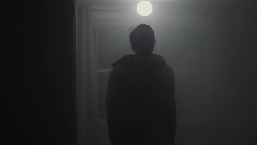 Man standing under a single light in a dark area