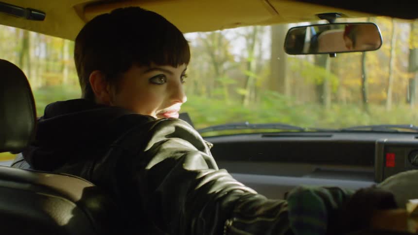 A woman rides as a passenger in a car