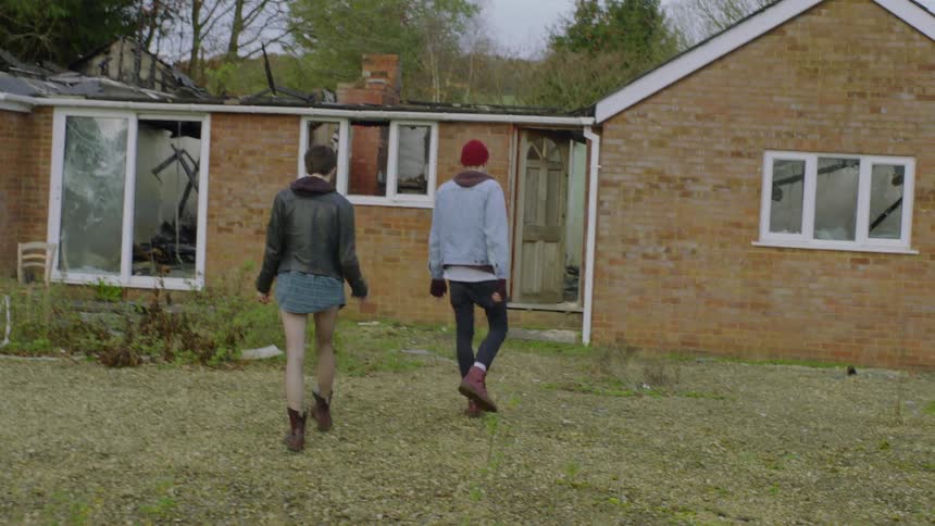 A man and woman approach a house