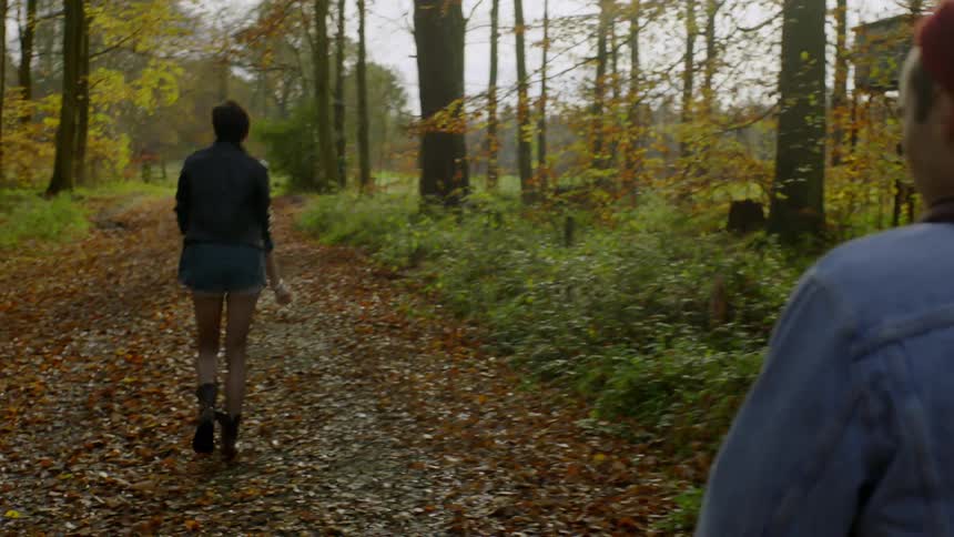 A man and woman hike in a forest in autumn