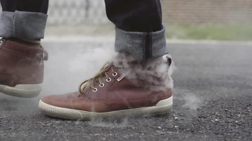 A man is walking down the street while smoking