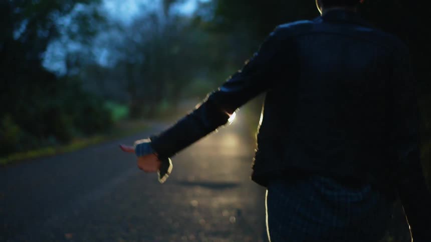 A woman and man try to hitch hike for a ride