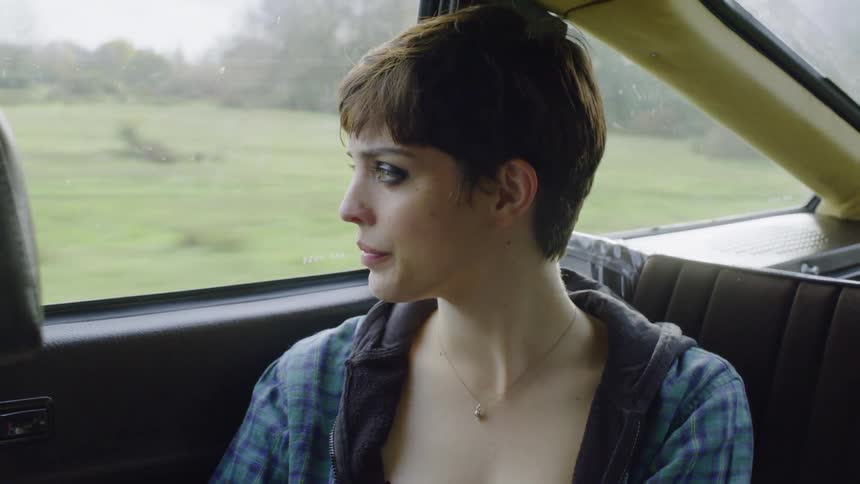 Woman drinks from a bottle in a moving car